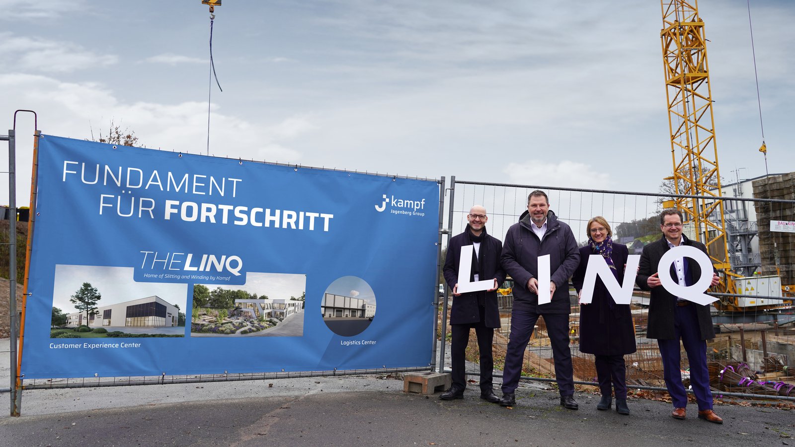 The picture shows 4 employees of Kampf in front of the construction site